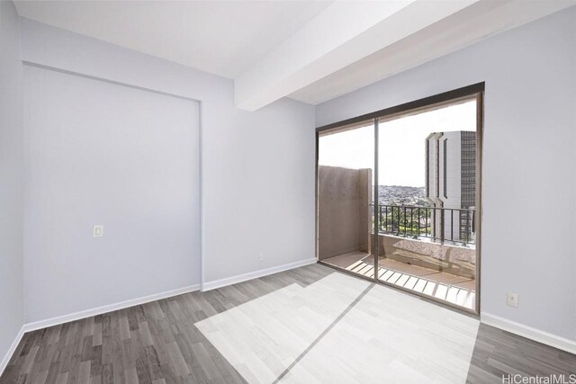 311 Ohua Ave Unit Ph D, Honolulu, HI 96815 - empty room with beam ceiling, baseboards, and wood finished floors