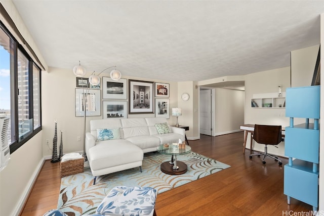 living area with baseboards and wood finished floors