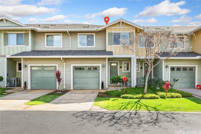 townhome / multi-family property featuring driveway, roof with shingles, and an attached garage