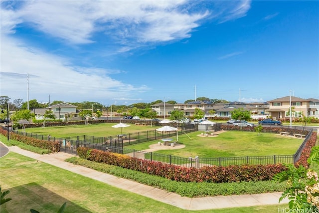 view of property's community with a yard, a residential view, and fence