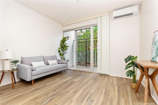 sitting room with light wood finished floors and a wall mounted air conditioner