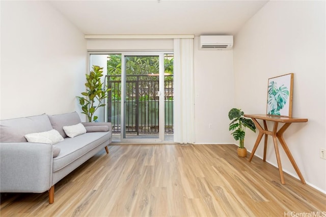 sitting room featuring a wall mounted air conditioner and wood finished floors