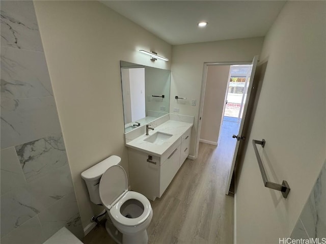 bathroom featuring recessed lighting, vanity, toilet, and wood finished floors