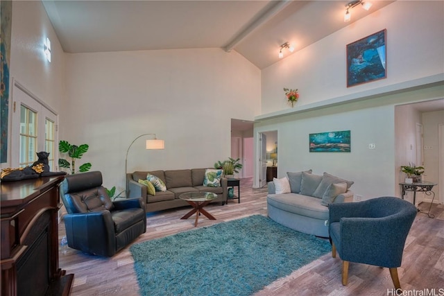 living area with high vaulted ceiling, beamed ceiling, and wood finished floors