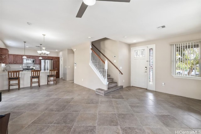 entryway with stairs, ceiling fan with notable chandelier, visible vents, and recessed lighting