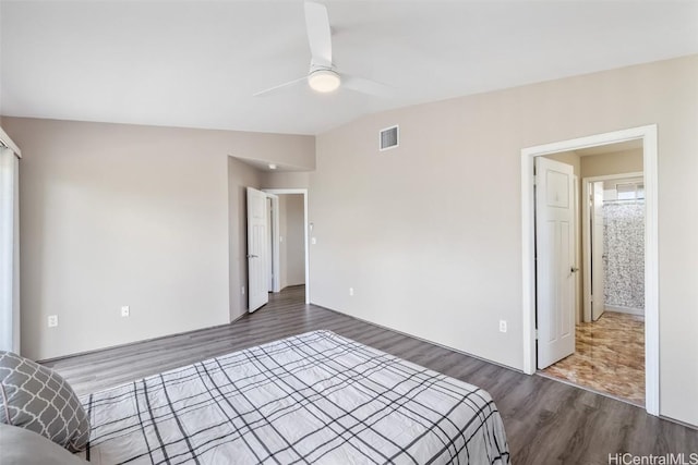 unfurnished bedroom with vaulted ceiling, ceiling fan, wood finished floors, and visible vents