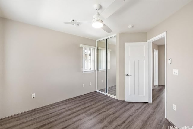 unfurnished bedroom with a ceiling fan, a closet, visible vents, and wood finished floors