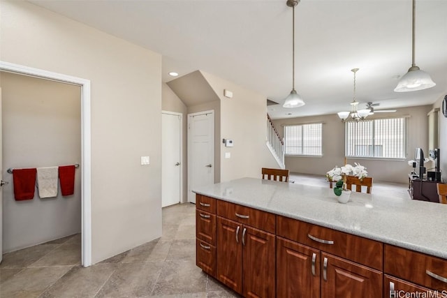 kitchen featuring a notable chandelier, decorative light fixtures, and light stone countertops