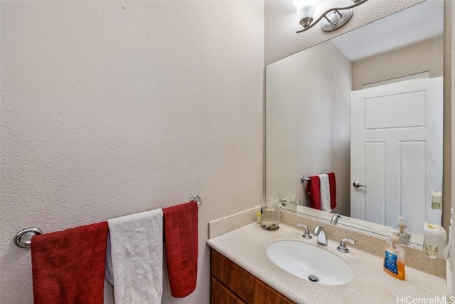 bathroom featuring a textured wall and vanity