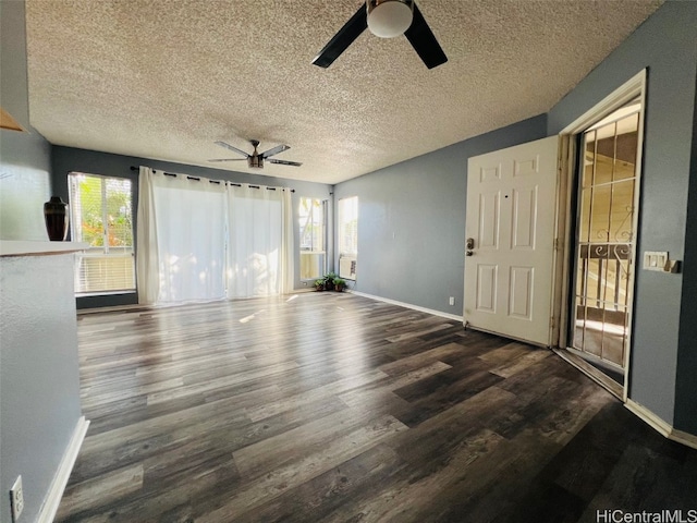 unfurnished living room featuring a ceiling fan, a healthy amount of sunlight, baseboards, and wood finished floors