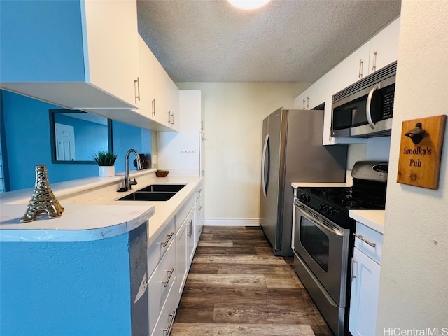 kitchen with white cabinets, dark wood-type flooring, stainless steel appliances, a textured ceiling, and a sink