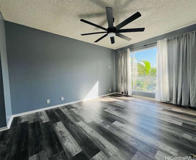 spare room with a textured ceiling, dark wood-style flooring, a ceiling fan, and baseboards