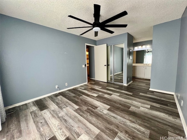 unfurnished bedroom featuring ceiling fan, connected bathroom, baseboards, and wood finished floors