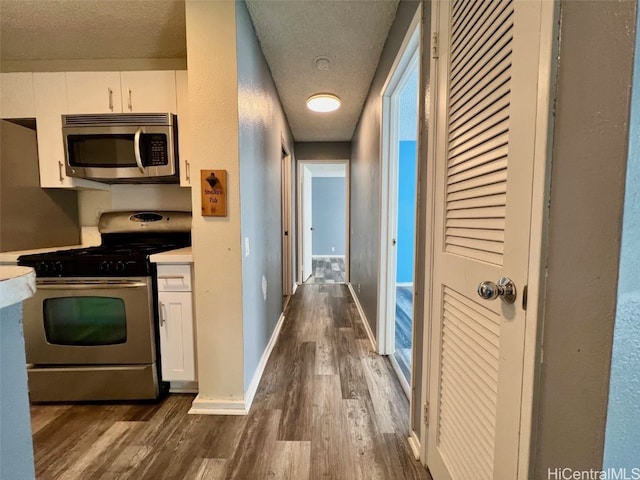 hall with dark wood-style flooring and baseboards