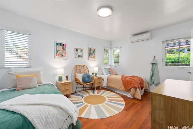 bedroom featuring a wall unit AC and wood finished floors