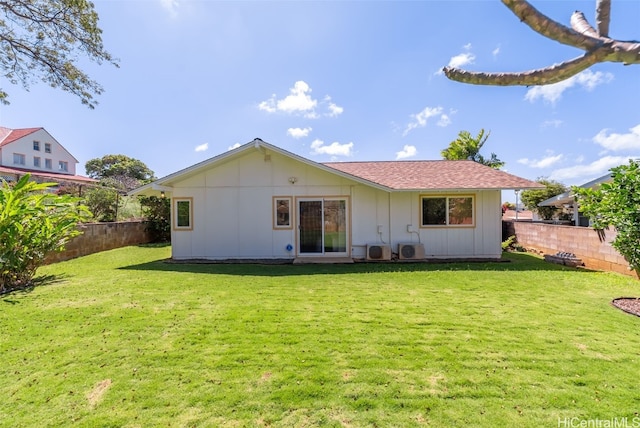 rear view of property featuring board and batten siding, a fenced backyard, and a lawn