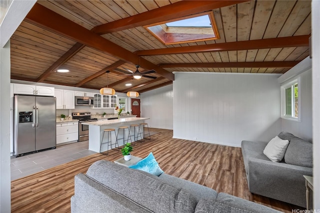 2445 Komo Mai Dr, Pearl City, HI 96782 - living area with wood ceiling, a ceiling fan, vaulted ceiling with skylight, and light wood finished floors
