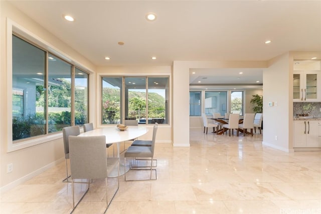 dining room featuring a healthy amount of sunlight, baseboards, and recessed lighting