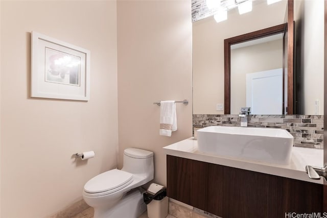 half bathroom featuring toilet, decorative backsplash, and vanity