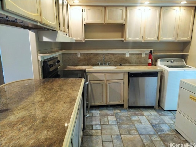 kitchen featuring range hood, a sink, stainless steel appliances, stone finish flooring, and washer and clothes dryer