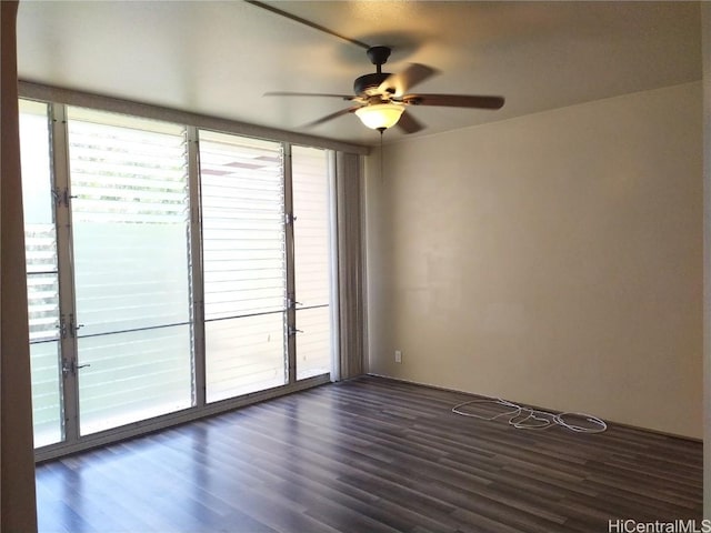 empty room featuring a ceiling fan and dark wood-style flooring