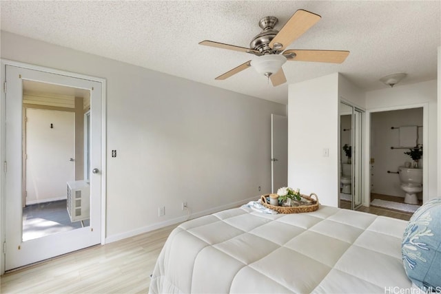 bedroom with a textured ceiling, ensuite bathroom, a ceiling fan, baseboards, and light wood-type flooring