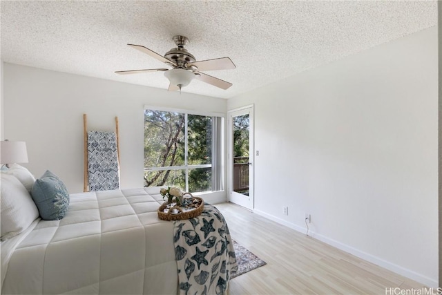 bedroom with baseboards, ceiling fan, access to outside, a textured ceiling, and light wood-style floors