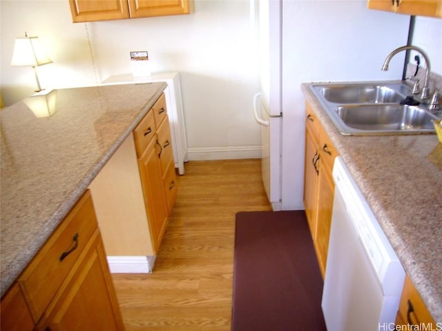 kitchen featuring light wood-style floors, baseboards, white dishwasher, and a sink