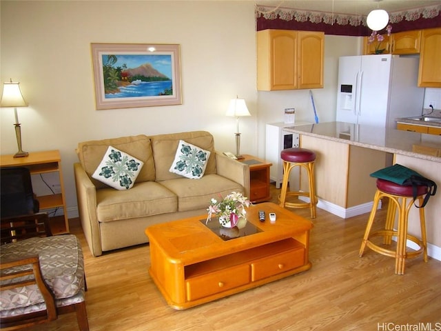 living area with light wood-type flooring and baseboards