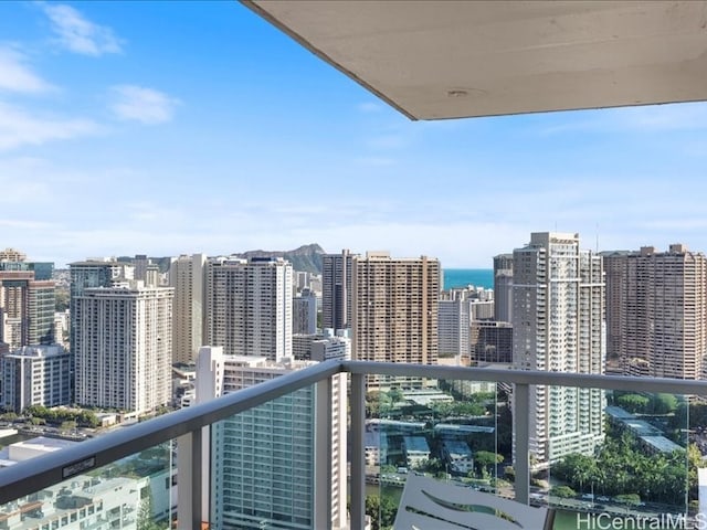 balcony featuring a water view and a city view