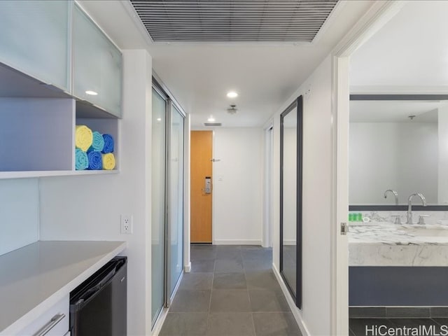 interior space with dark tile patterned floors, a sink, visible vents, and recessed lighting