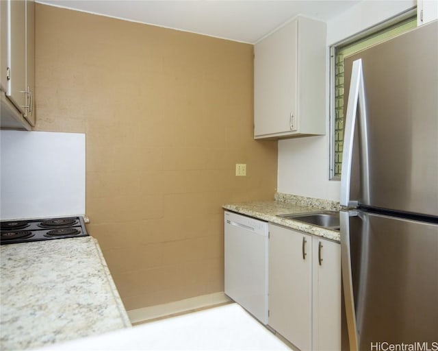 kitchen featuring light countertops, freestanding refrigerator, white cabinets, a sink, and dishwasher