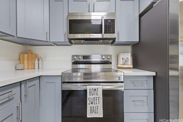 kitchen with gray cabinets, appliances with stainless steel finishes, and light countertops