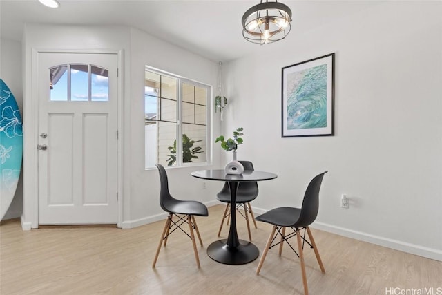 dining space featuring light wood-style flooring and baseboards