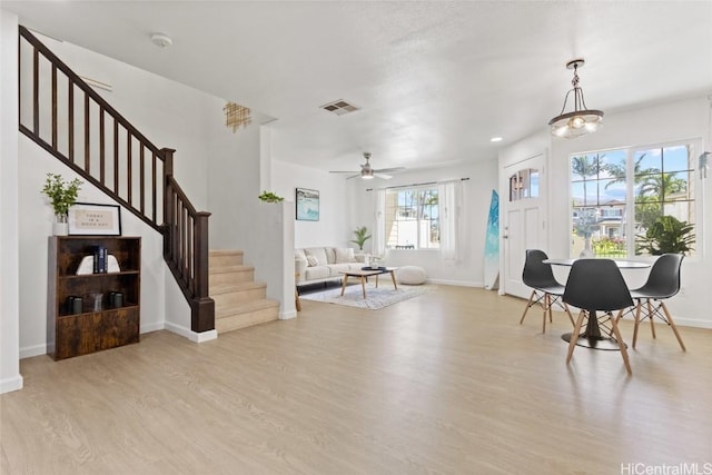 foyer entrance featuring stairway, light wood-type flooring, visible vents, and baseboards