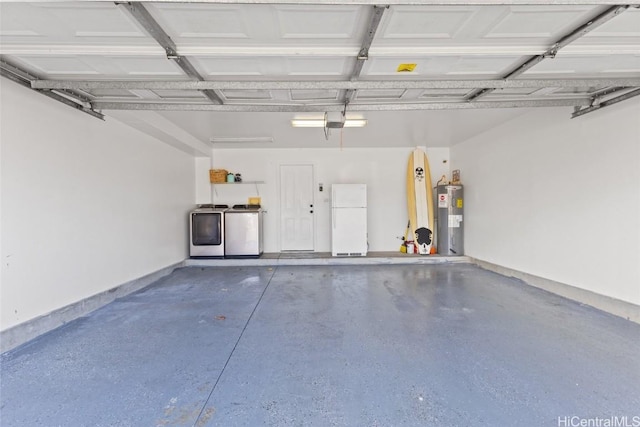 garage with washing machine and dryer, electric water heater, baseboards, and freestanding refrigerator