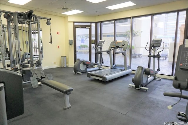 gym featuring a paneled ceiling, baseboards, and visible vents