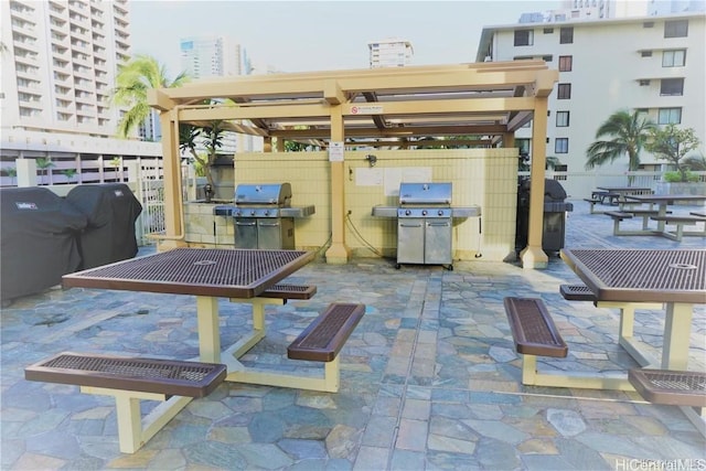 view of patio / terrace featuring grilling area, fence, and a city view