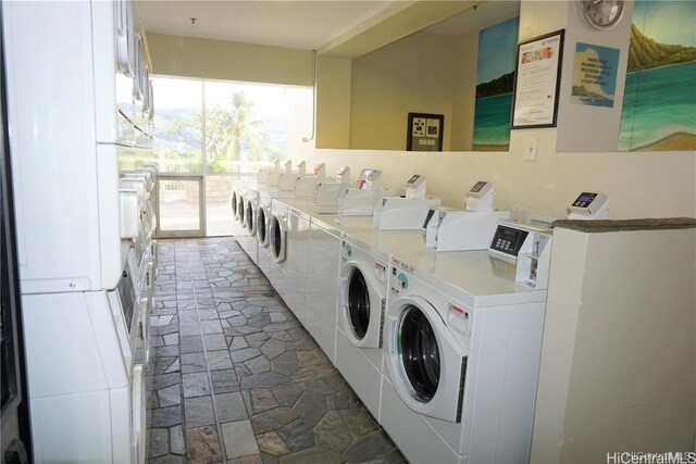 shared laundry area featuring stone finish flooring and separate washer and dryer