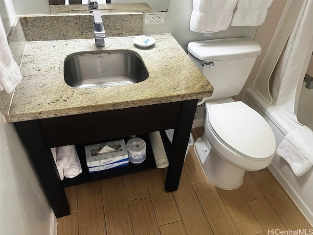 full bathroom featuring toilet, shower / bathtub combination with curtain, wood finish floors, and vanity