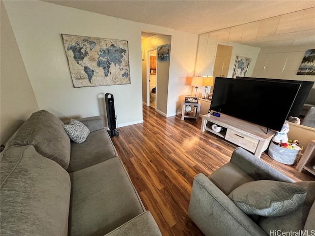 living area with baseboards and wood finished floors