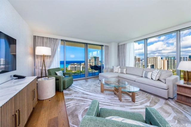 living area with a wall of windows, a healthy amount of sunlight, a city view, and light wood finished floors