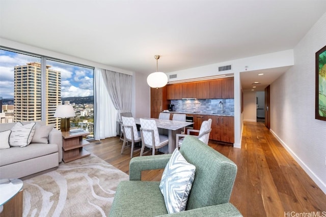 living area featuring dark wood-type flooring, visible vents, and baseboards