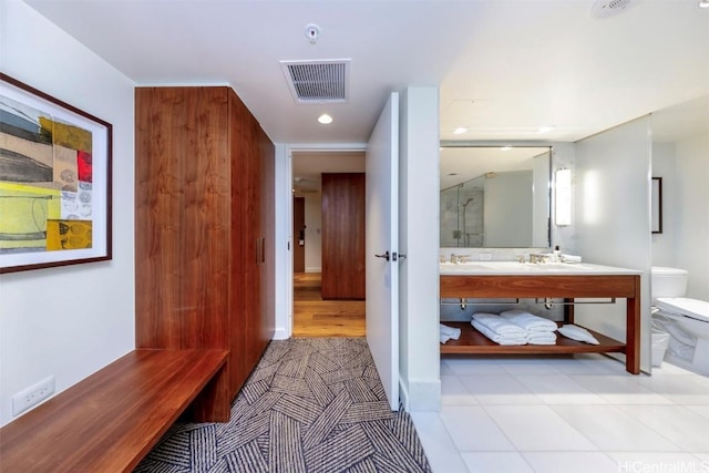 interior space featuring toilet, vanity, a shower stall, and visible vents