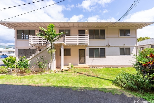 back of house featuring a yard and stairway