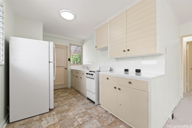 kitchen with a sink, white appliances, light countertops, and crown molding