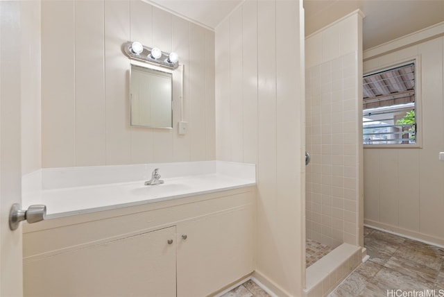 full bath with a tile shower and vanity