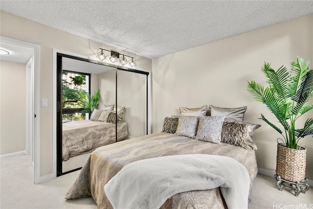 carpeted bedroom featuring a textured ceiling, baseboards, and a closet