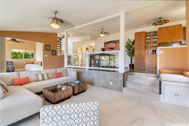 carpeted living area with vaulted ceiling and a ceiling fan