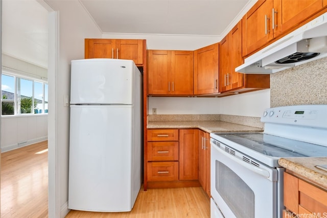 kitchen featuring light wood-type flooring, white appliances, brown cabinets, and under cabinet range hood